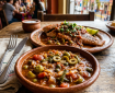 Mexican meal with saucy fish and vegetables in clay dishes